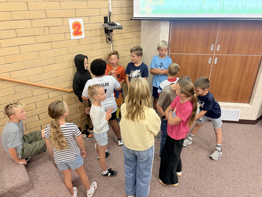 Students participating in a Falcon Flight lesson by playing Four Corners, talking with classmates, and building connections with other Falcons.