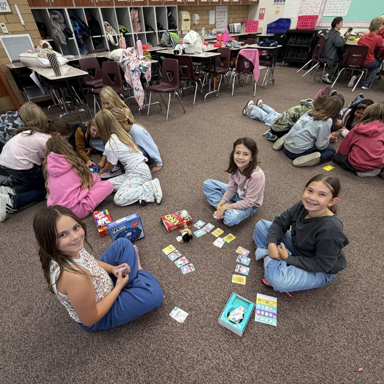 Students sitting on the floor in a circle playing board games!