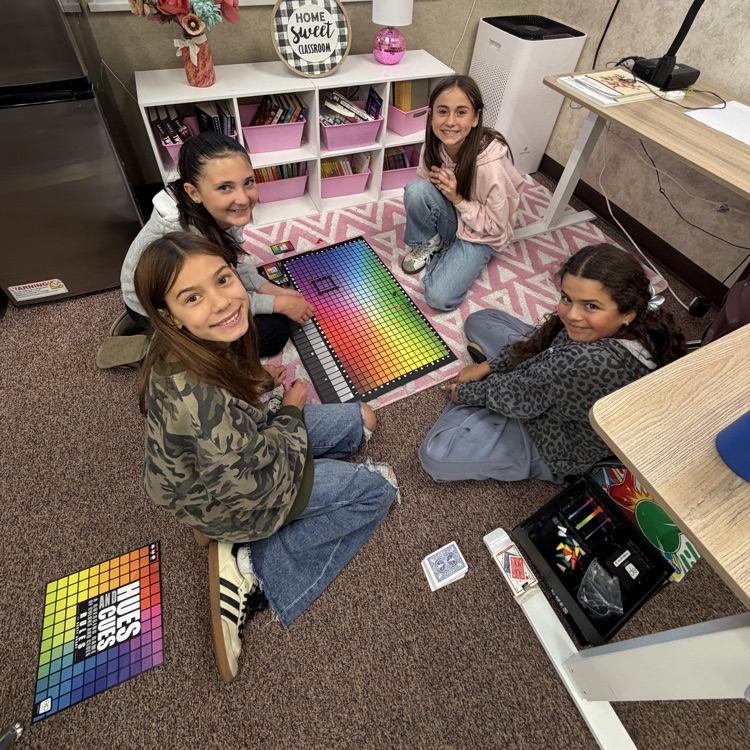 Students sitting on the floor in a circle playing board games!