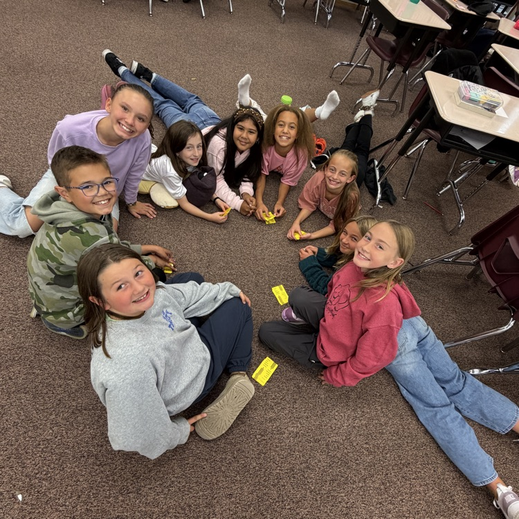 Students sitting on the floor in a circle playing board games!