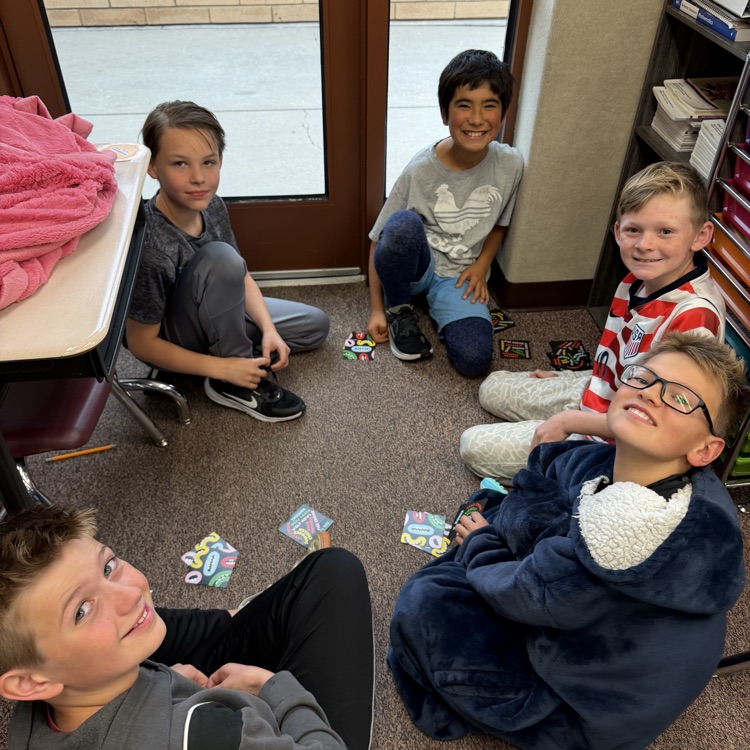 Students sitting on the floor in a circle playing board games!