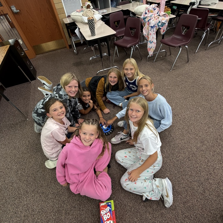 Students sitting on the floor in a circle playing board games!