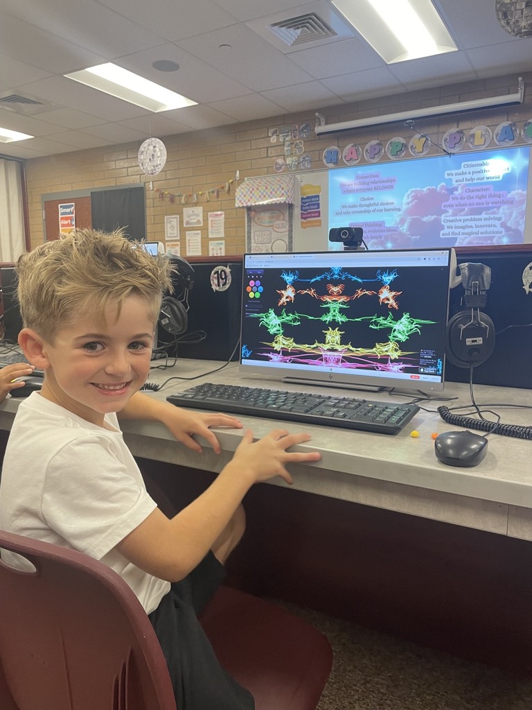 student smiling while on the computers