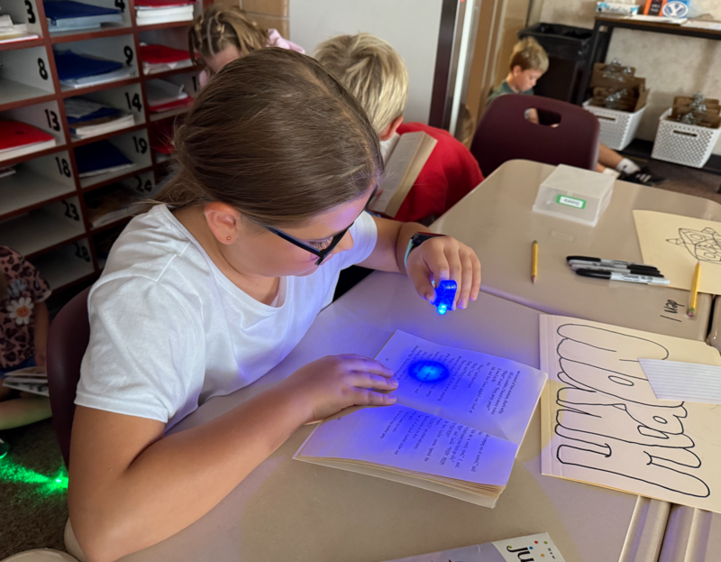 student reading with glow int he dark light