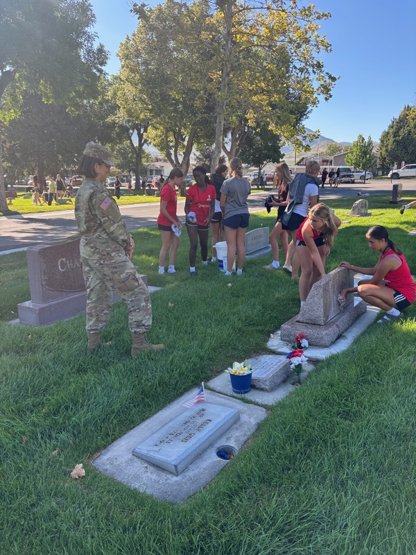 students cleaning headstones