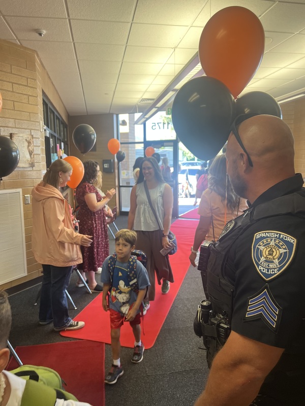 kids walking on the red carpet into the school.