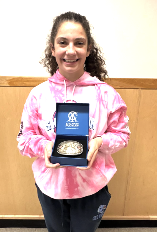 Ruby Lindstrom wins 1st at Skyhawk showdown. She is holding her medal. 