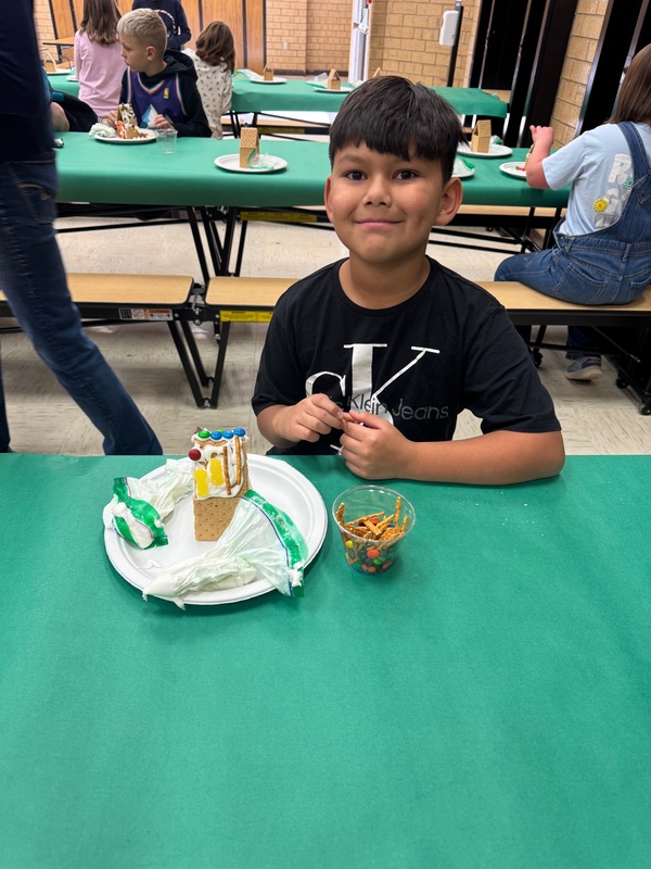 student with gingerbread house