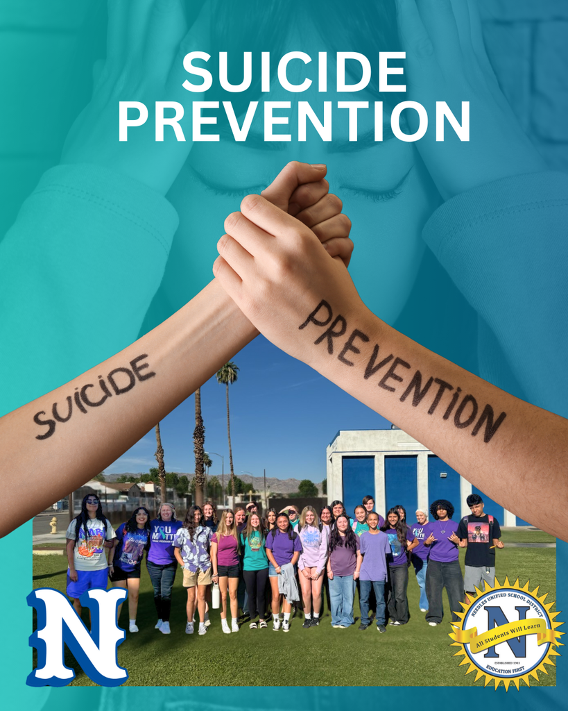Two arms with "Suicide Prevention" written on them are raised against a background of a group of people standing on grass, conveying unity and awareness.
