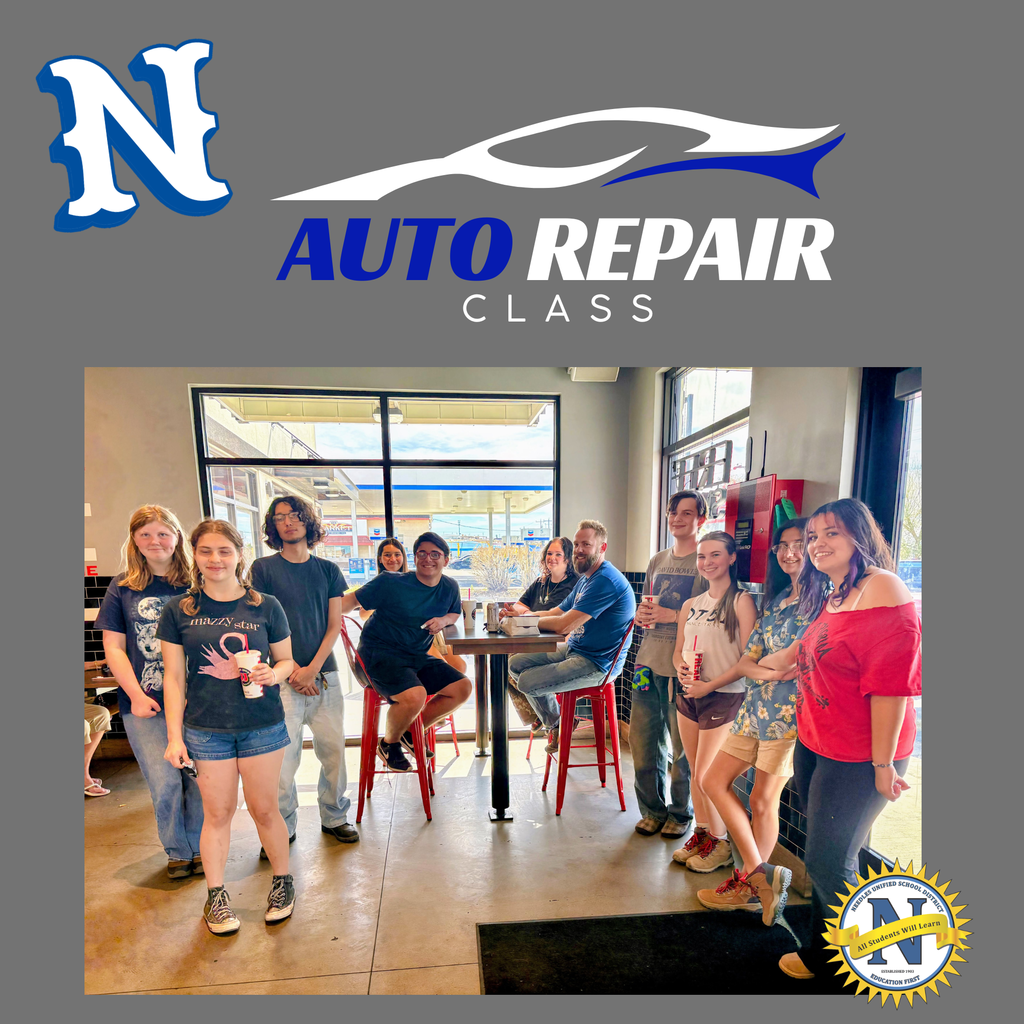 **Alt Text:** Graphic reading “N Auto Repair Class” above a photo of an auto repair teacher and several high school students standing together inside a sandwich shop during a class fundraiser. The group stands around a high table holding drinks, smiling and posing for the photo. A school district seal appears in the bottom corner.