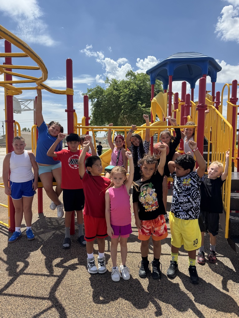Students flexing their muscles on the playground.