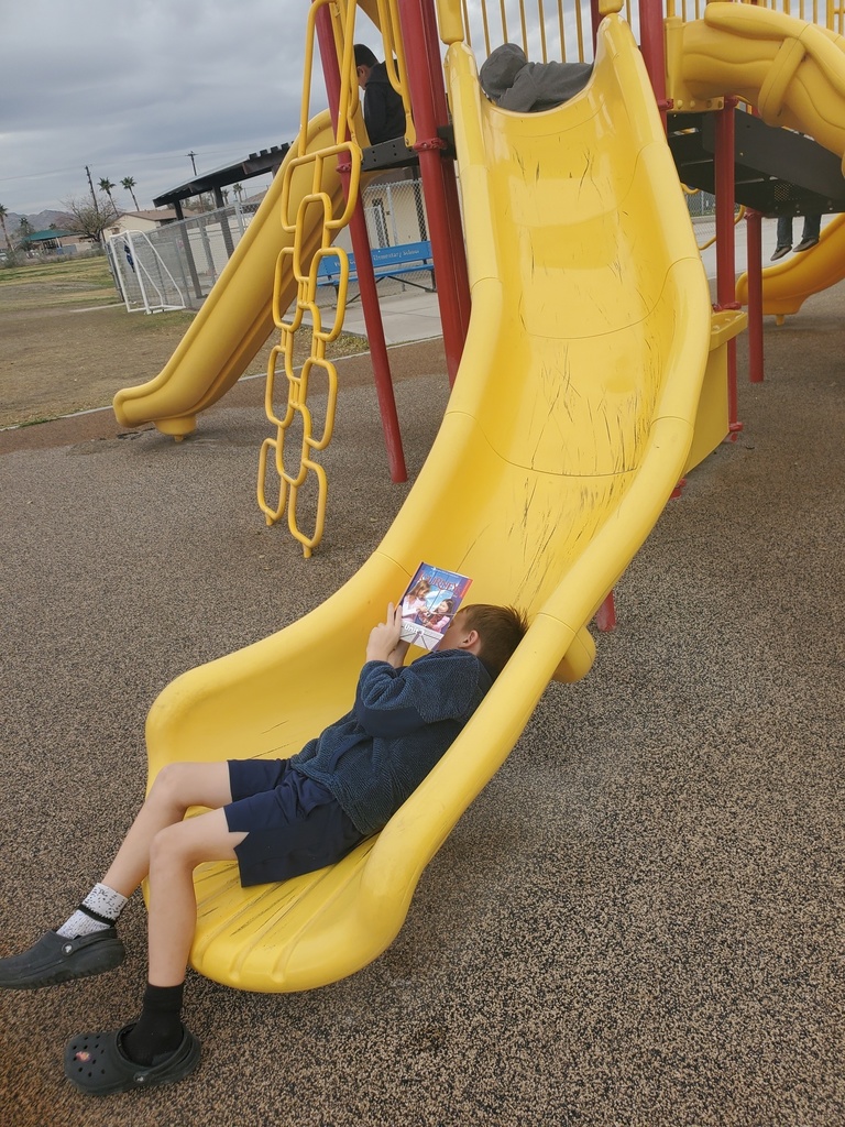 Student reading laying down in slide.