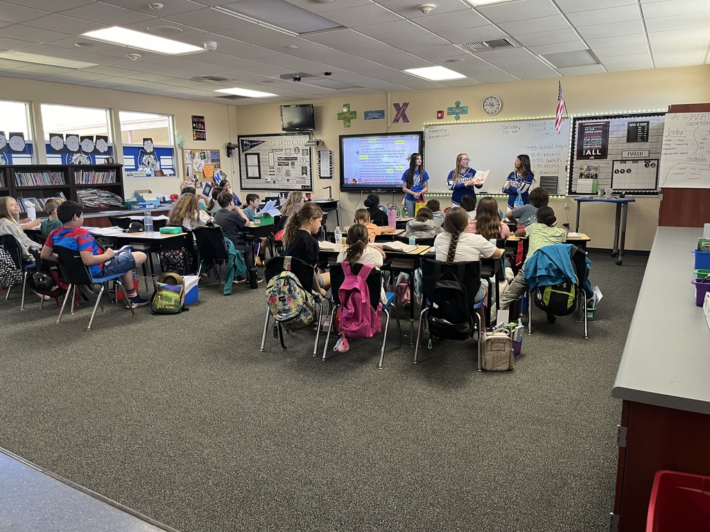 Cheerleaders reading to students.