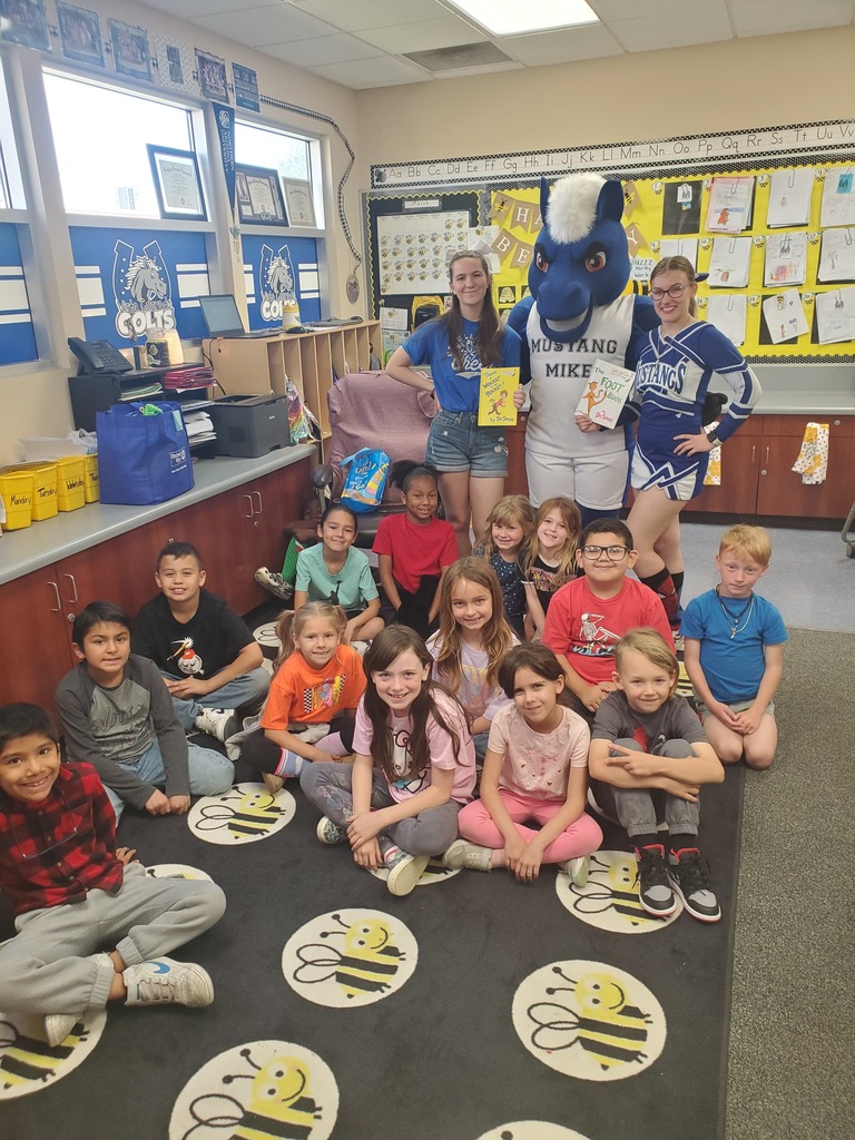 Cheerleaders and mastcot with students.