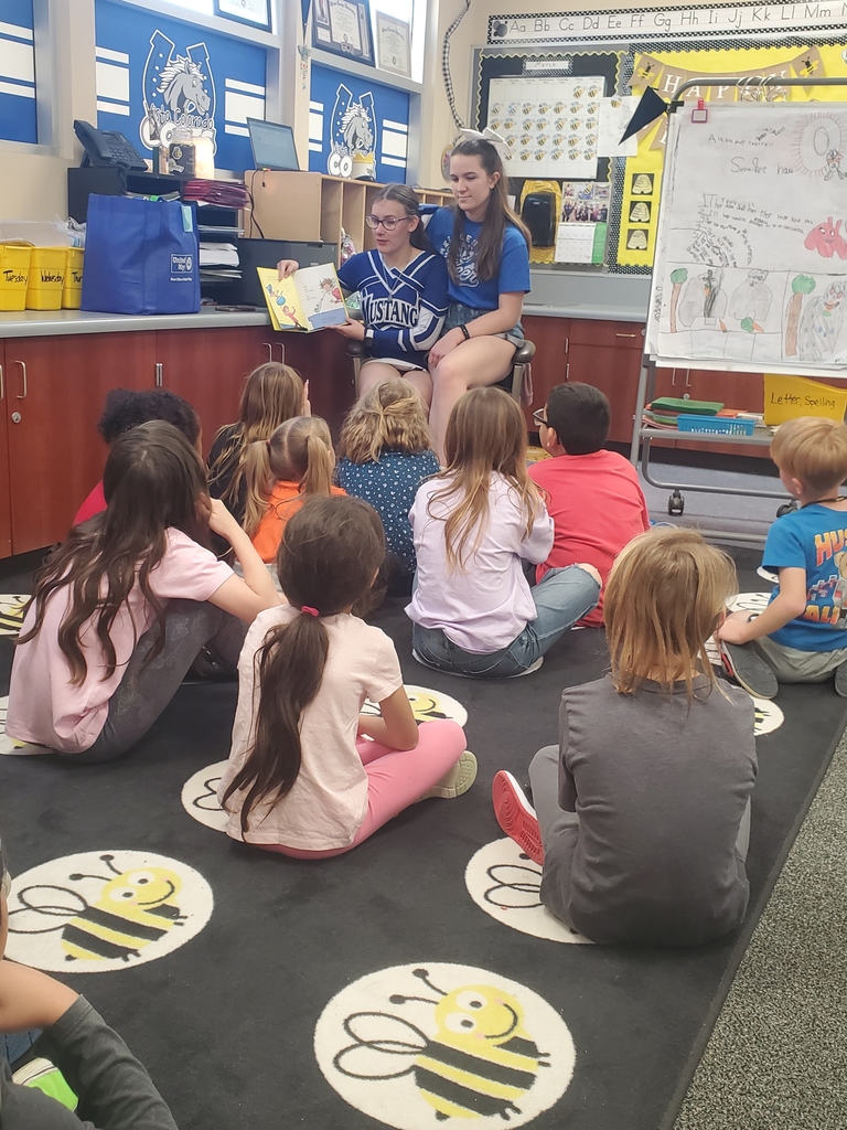 Cheerleaders reading to students.