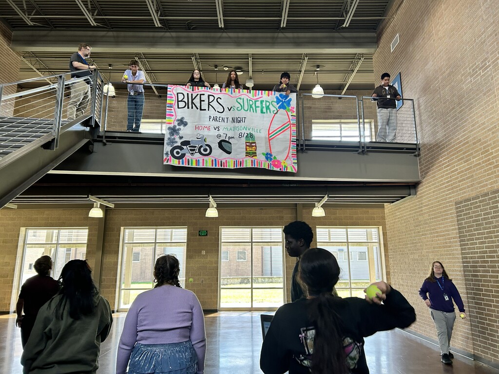 Students bouncing tennis balls off of main stairwell to study acceleration