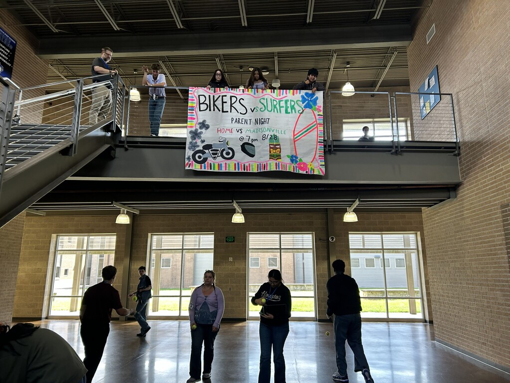 Students bouncing tennis balls off of main stairwell to study acceleration