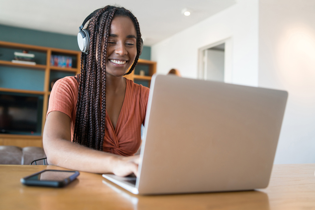 Image by Mego-Studio on Magnific - image of a female student with headphones and a laptop learning from home
