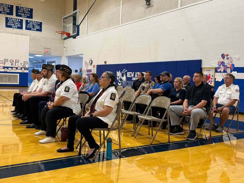 Veterans, VFW members, first responders, and community guests sit together in the New Athens school gym during a Veterans Day program.