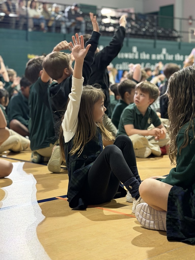 younger girl sitting down and raising her hand