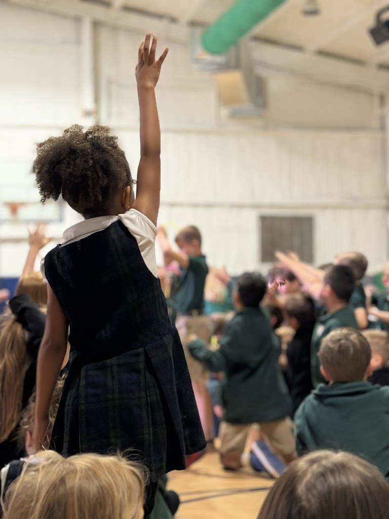 younger girl standing and eagerly raising hand