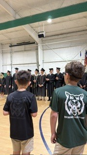 elementary boys looking at graduating seniors
