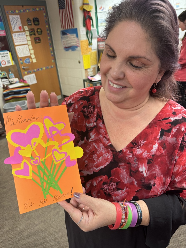 Mrs. Sorrell holding up a student's card for a family member