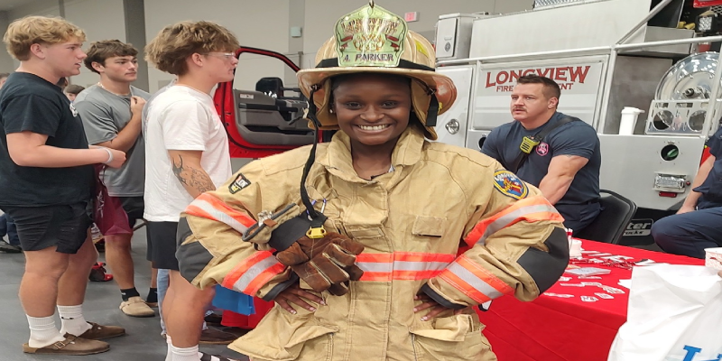 Student trying on Firefighter gear at College and Career Fair
