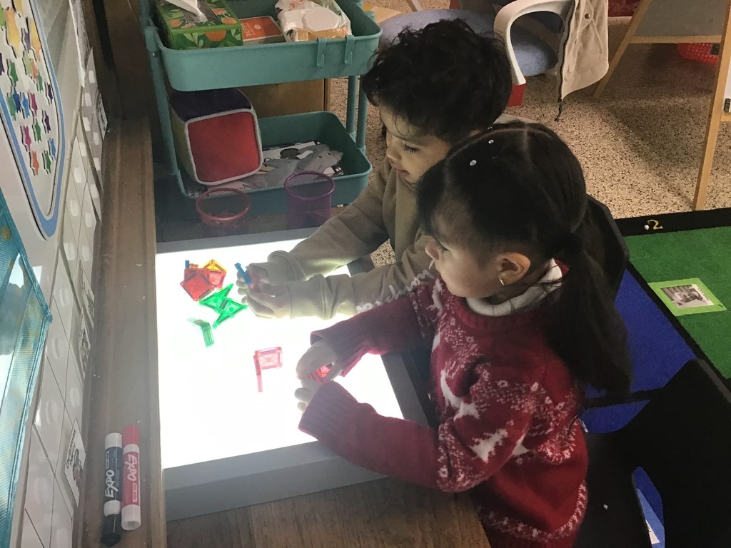 These three year olds have been busy in December! The students sorted in the sensory table with magnetic wands, jingle bells, tinsel, and pompoms. They played with their peers in the dramatic play center with a hot cocoa stand, Christmas baking, and a tree to decorate. In the writing center, the students wrote letters to Santa and  put them in the mailbox to send them to the North Pole. In art, the preschoolers painted with pine boughs and created their own reindeer directed drawing. So many engaging ways to learn and play with friends!