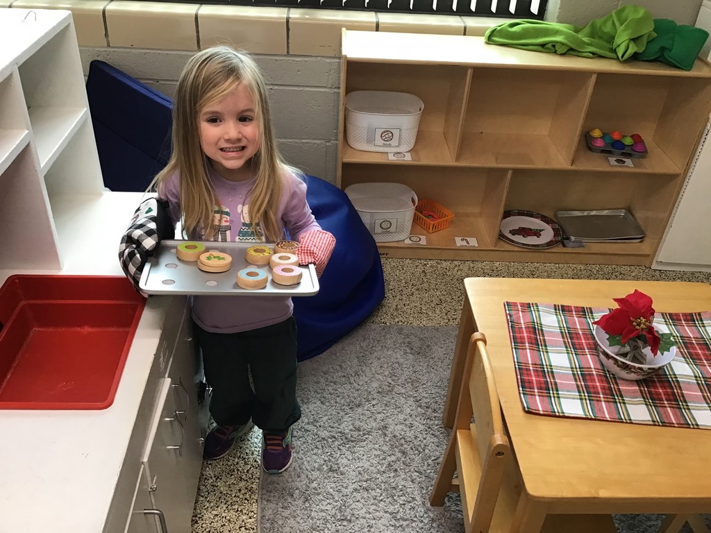 These three year olds have been busy in December! The students sorted in the sensory table with magnetic wands, jingle bells, tinsel, and pompoms. They played with their peers in the dramatic play center with a hot cocoa stand, Christmas baking, and a tree to decorate. In the writing center, the students wrote letters to Santa and  put them in the mailbox to send them to the North Pole. In art, the preschoolers painted with pine boughs and created their own reindeer directed drawing. So many engaging ways to learn and play with friends!