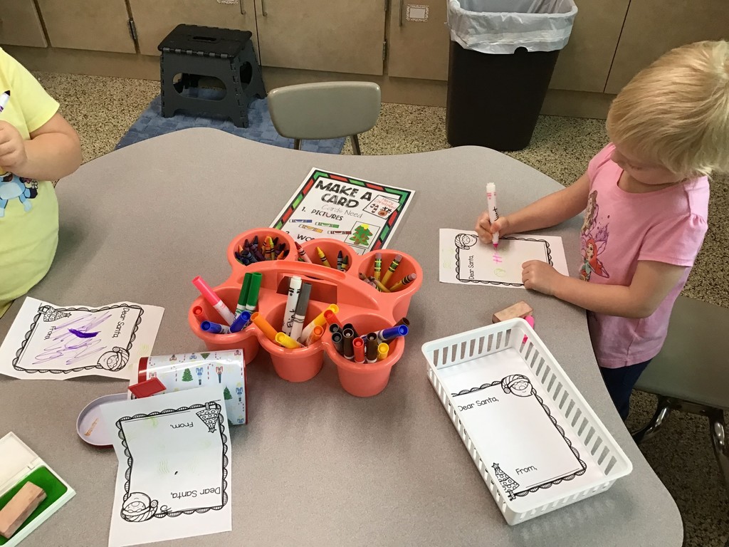 These three year olds have been busy in December! The students sorted in the sensory table with magnetic wands, jingle bells, tinsel, and pompoms. They played with their peers in the dramatic play center with a hot cocoa stand, Christmas baking, and a tree to decorate. In the writing center, the students wrote letters to Santa and  put them in the mailbox to send them to the North Pole. In art, the preschoolers painted with pine boughs and created their own reindeer directed drawing. So many engaging ways to learn and play with friends!