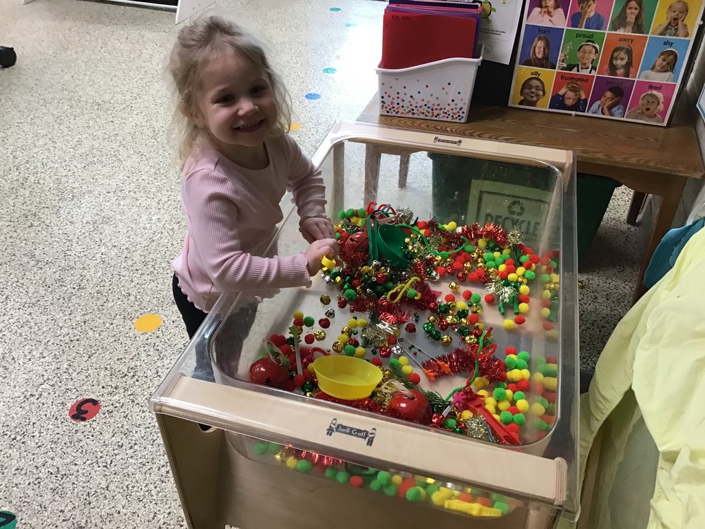 These three year olds have been busy in December! The students sorted in the sensory table with magnetic wands, jingle bells, tinsel, and pompoms. They played with their peers in the dramatic play center with a hot cocoa stand, Christmas baking, and a tree to decorate. In the writing center, the students wrote letters to Santa and  put them in the mailbox to send them to the North Pole. In art, the preschoolers painted with pine boughs and created their own reindeer directed drawing. So many engaging ways to learn and play with friends!