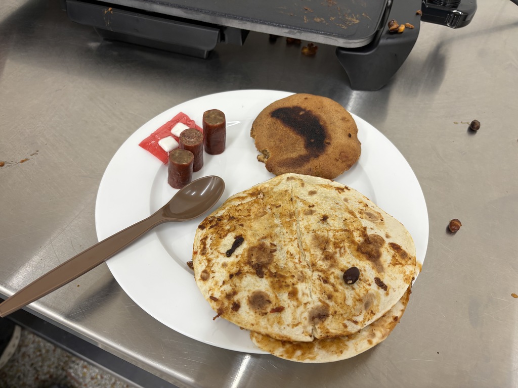 Foods II (two sections) had a guest speaker (Tristan Vanatta) from the National Guard. Vanatta did an MRE (meals ready to eat) challenge with both sections. The student could add ingredients and spices to their dish. Plating and taste were judge and the winners were freshmen: Camden Bruess, Ben Carlton, Cade Orr, and Kingsley Paulsen. Mrs. Schmitt did not get a picture of the winning meal, but of a few of the runner-ups.