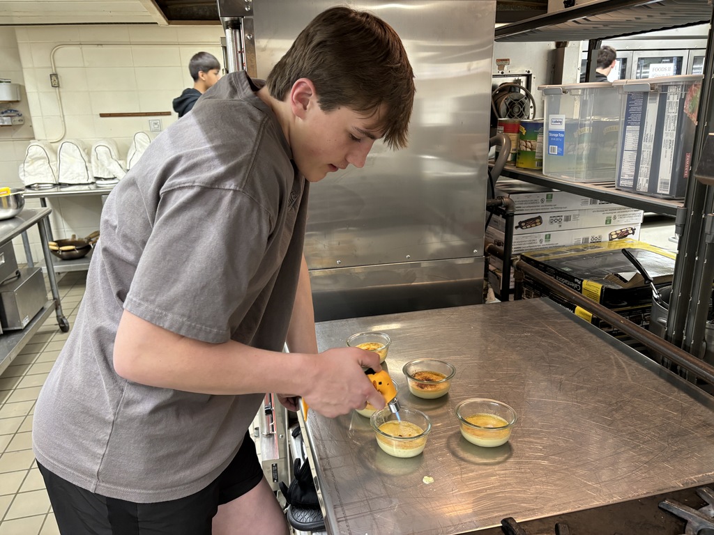 Cooking Around the World is continuing to learn about Europe. The pastries this week were crepes and crème brûlée, both from France. Crème brûlée is a difficult dessert to make and needs to be done just right. Mrs. Schmitt brought her torch from home, and the students had fun caramelizing the sugar on top. 