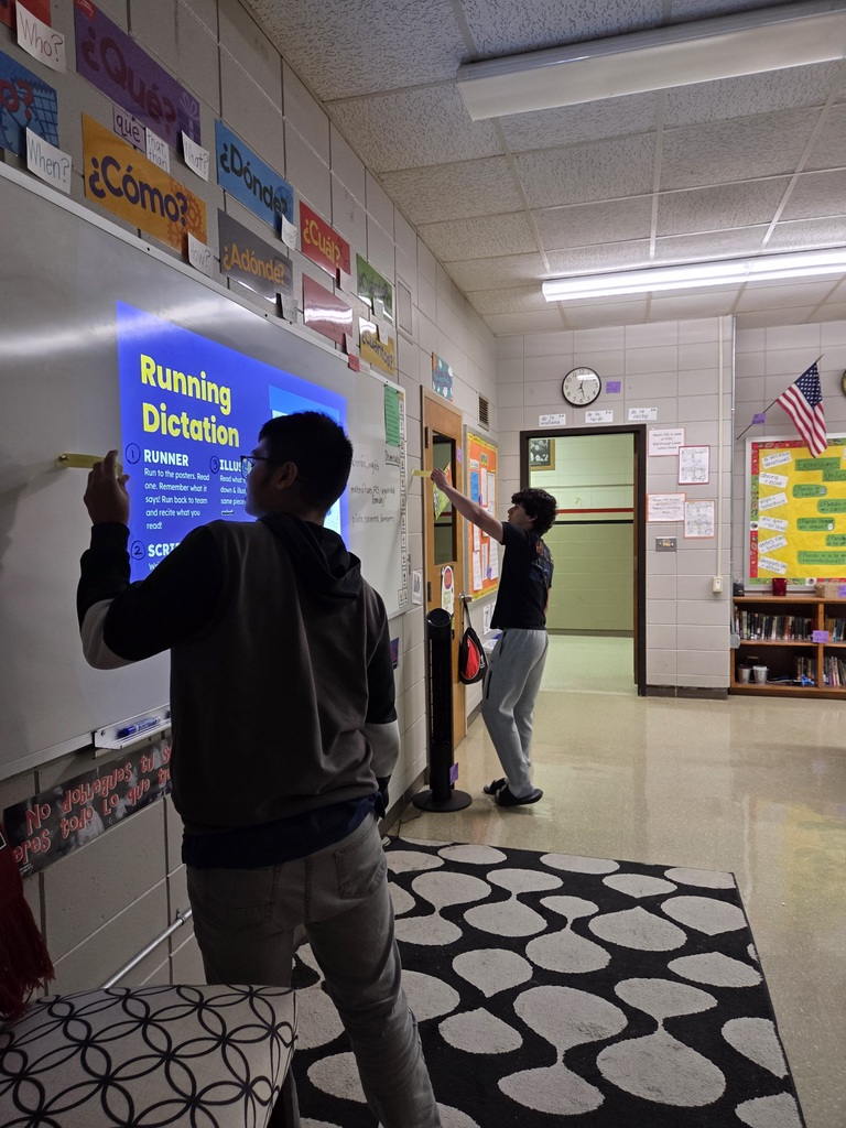 Students in Mrs. Macon's Spanish I classes did an activity called "Running Dictation." Parts of the class story from the previous day are placed around the room. Students are put into teams of 4 with different roles assigned: Runner, Scribe, Illustrator, and Cheerleader. The runner visits each "station" and returns to their group to report the information in Spanish. The Scribe writes in Spanish what the Runner said. The paper is passed to the Illustrator who has to read the Spanish and draw a picture of it. And the cheerleader encourages and helps the team. The roles rotate so that all students are using the skills of speaking, listening, writing, and reading.