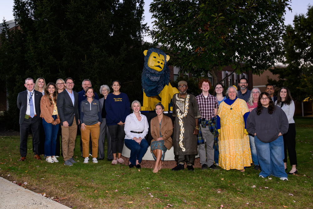 group of individuals surrounding Lion sculpture