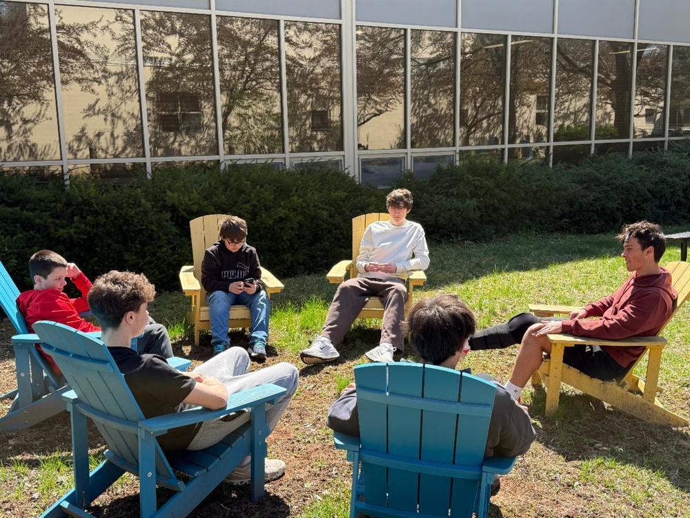 LionLink 8th graders and high schoolers sitting on chairs outside