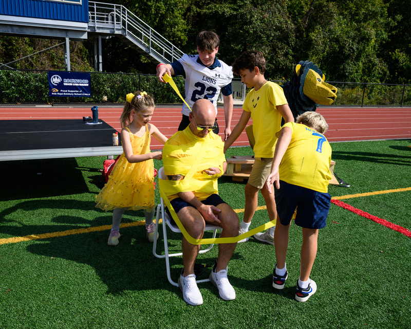 students wrapping principal in streamers