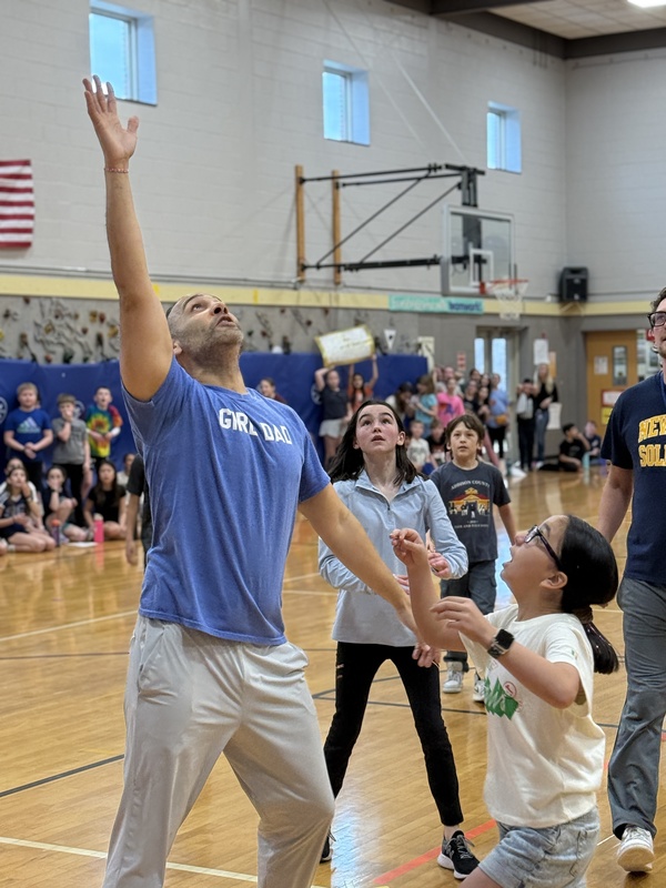 teacher and student reaching for basketball