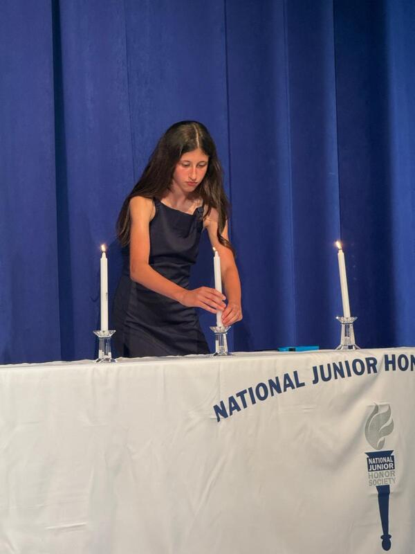 National Jr honor society member lighting a candle