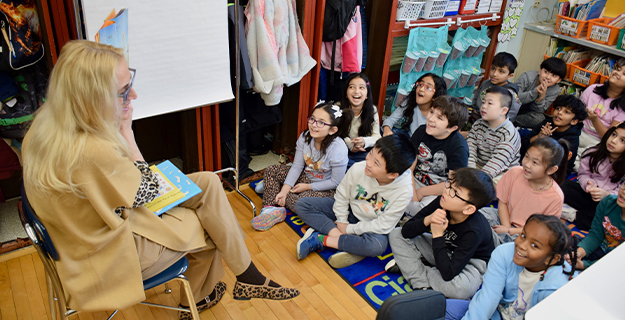 Teacher reading to excited students.