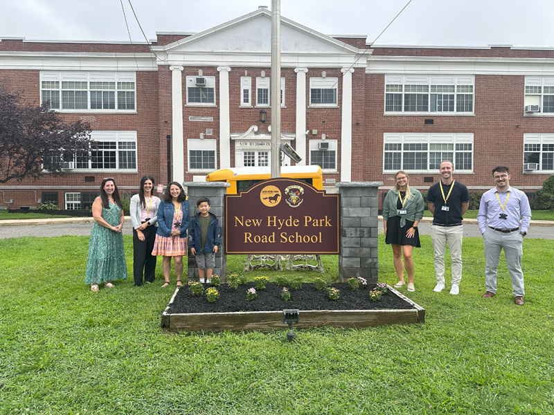 people outside by the school sign