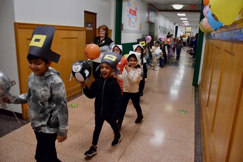 Students walking through hallway in Thanksgiving costumes.