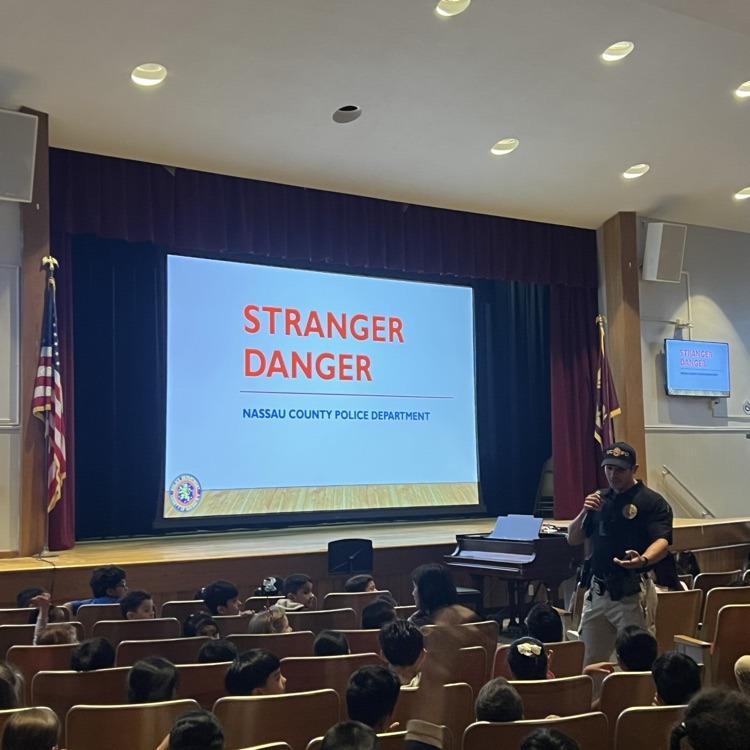 kids to an auditorium listening to an assembly