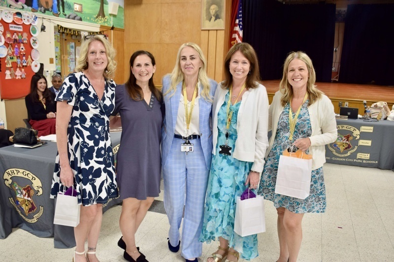 five women standing together indoors