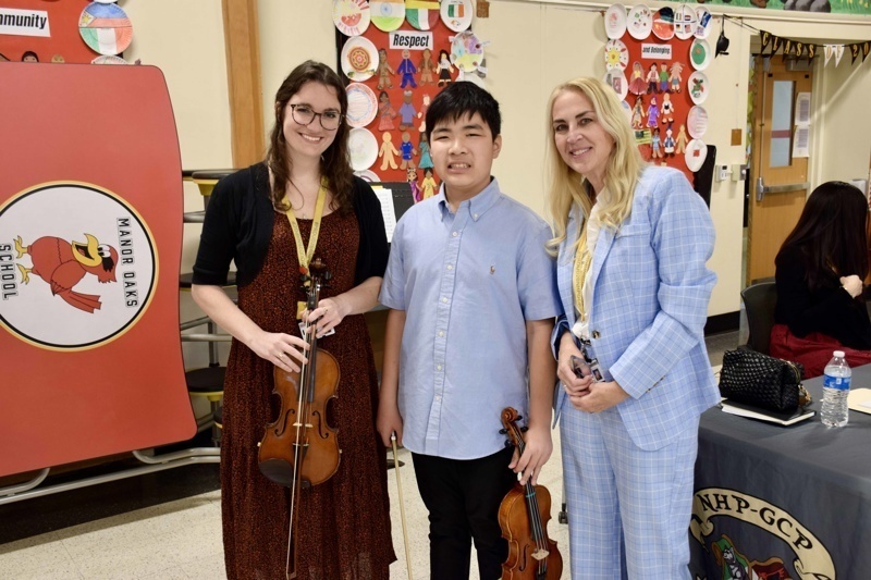 students holding violins in school setting