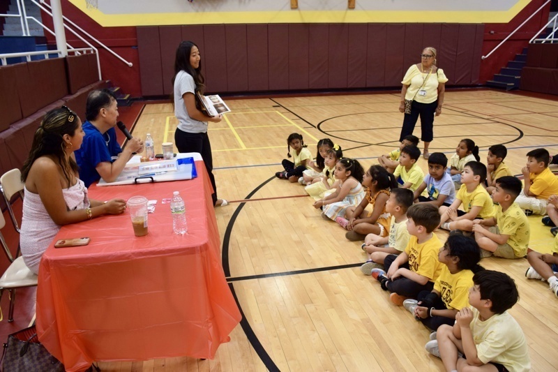 children sitting on gym floor listening
