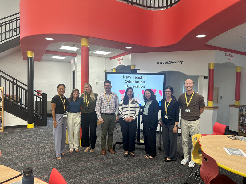 people pose by a presentation screen