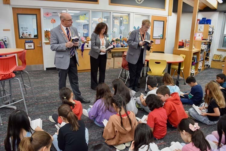Students listening to assmebly in library.