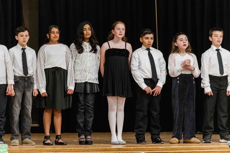 Students singing on stage.
